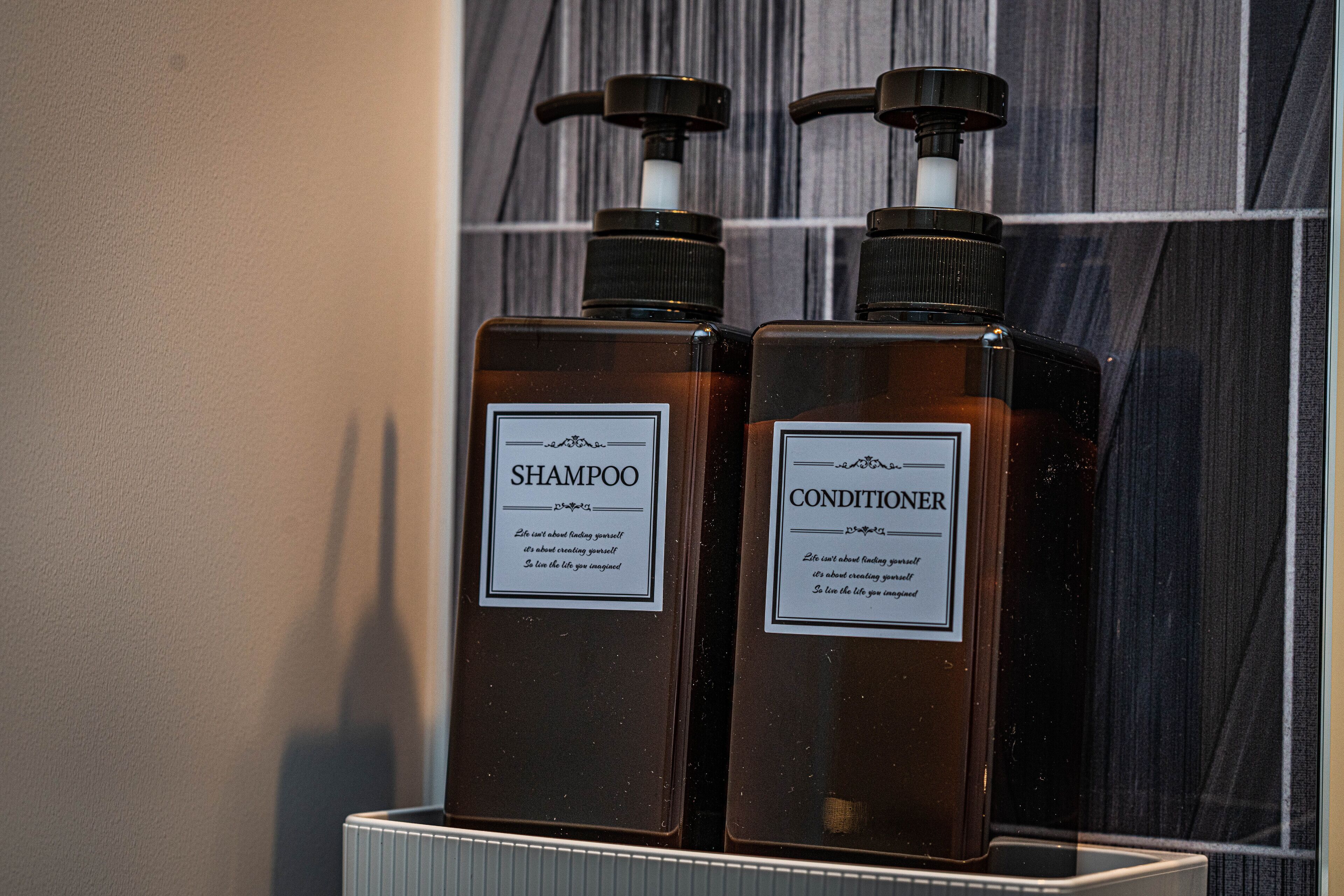 Two bottles of shampoo and conditioner on a shelf.