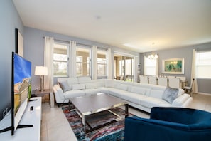 A modern living room with a sectional sofa, a coffee table, and a TV.