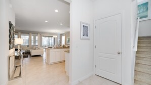 A spacious, well-lit interior with a kitchen, dining area, and living room. - Oakshaddows Villa Windsor At Westside (Davenport)