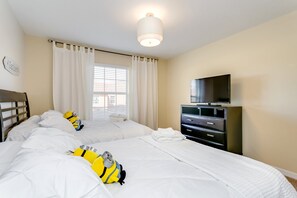A hotel room with two beds, a flat-screen TV, a dresser, and a window with curtains. - Bismark Villa Windsor At Wesside (Kissimmee)