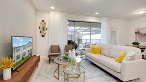 A modern living room with a television, sofa, and coffee table. - Sydney Villa Windsor At Westside 1 (Kissimmee)