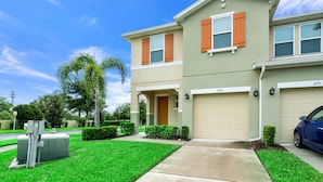 A two-story house with a beige exterior, orange shutters, and a garage door number 3191.