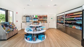 A retail area with a central display and shelves stocked with various products. - Cooper Villa Windsor At Westside (Kissimmee)