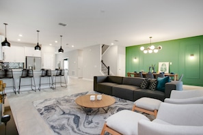 A modern living room with a gray sofa, white armchairs, and a coffee table. - Target Villa Story lake (Kissimmee)