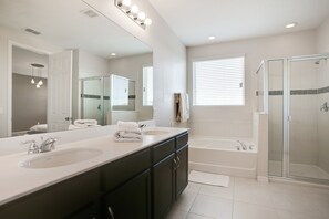 A modern bathroom with two sinks, a large mirror, a bathtub, and a glass-enclosed shower. - Carribean View Villa Solara 2 (Kissimmee)