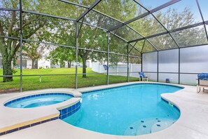 An outdoor swimming pool with a glass enclosure, surrounded by a grassy area and trees. - 436 Aldridge Lane 6 Bedroom Executive Pool and Sp (Davenport)