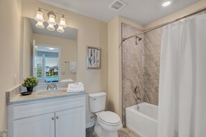A bathroom with a sink, toilet, bathtub, and shower curtain. - Oakmoss drive Solterra 3 (Davenport)