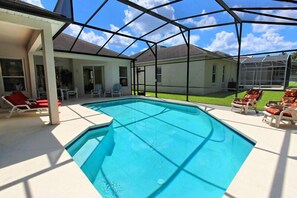 Uma piscina descoberta coberta, com espreguiçadeiras e um espaço de pátio.