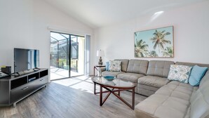 A modern living room with a sofa, TV, and a glass coffee table. - Victoria Villa Porvidence 4 (Davenport)