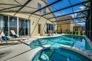 A covered outdoor swimming pool with lounge chairs and a patio area.