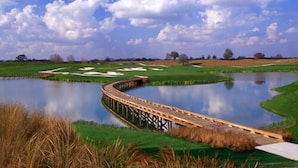 A wooden bridge over a calm body of water with a clear sky and greenery around. - Excitmen t Drive Condo Reunion (Kissimmee)