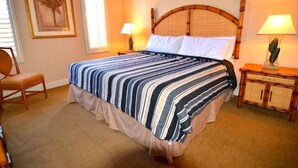 A neatly made bed with striped bedding, two bedside lamps, a wooden nightstand, a framed picture on the wall, and a chair. - 3500cal Stunning Town Home In Regal Plams (Davenport)