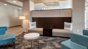 A modern hotel lobby with a sofa set, a round table, and a lamp.