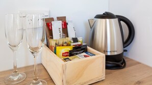 Een houten doos met verschillende chocoladerepen en een waterkoker, op een houten ondergrond.