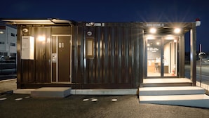 A small, modern building with two entrances, each marked with a number. - Hotel R9 The Yard Ashikagaekinishi (Ashikaga)