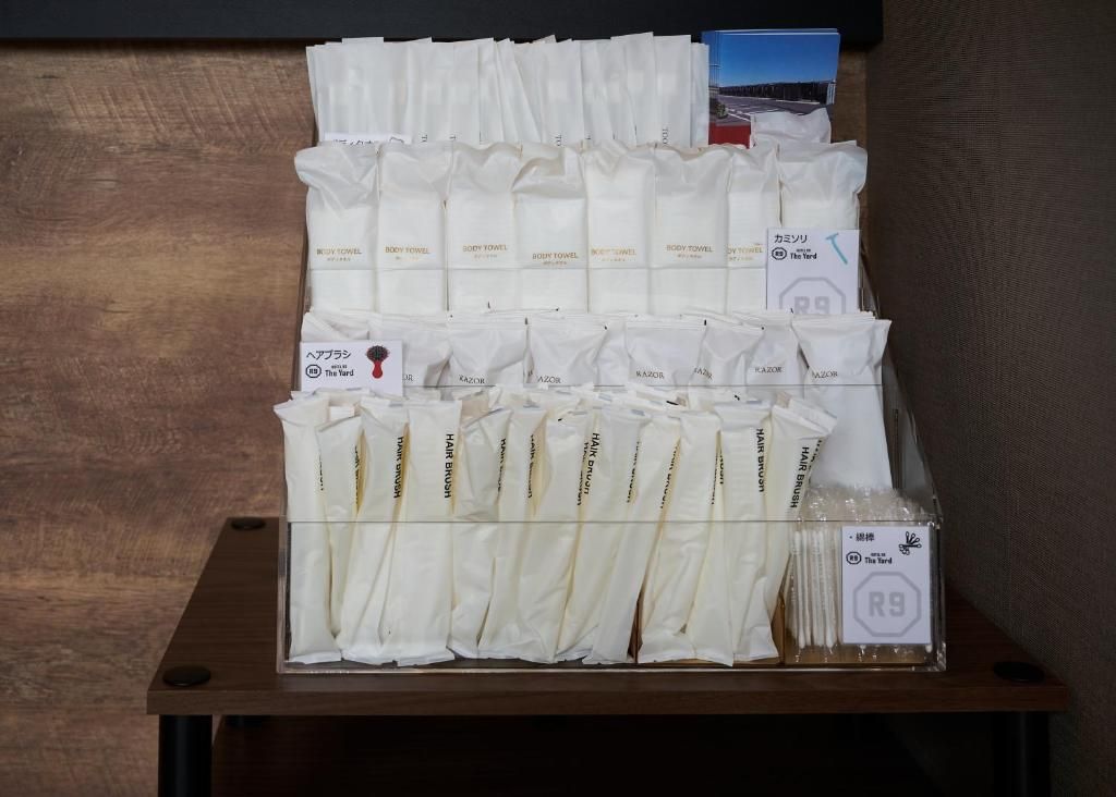 A display of hotel amenities including body towels, hair brushes, and a card with hotel branding.
