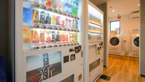 A vending machine with various beverages and a laundry area with washing machines. - Hotel R9 The Yard Ashikagaekinishi (Ashikaga)