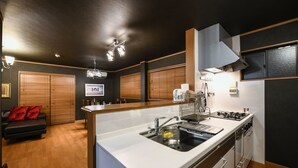 Una cucina moderna con isola centrale, mobili in legno e piano di lavoro nero.