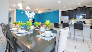 A modern kitchen with dark cabinets, a stainless steel refrigerator, and a microwave. - Family Friendly 4Bd with Pool Solara Resort 1517 (Kissimmee)