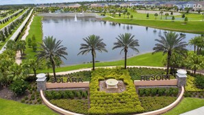 A resort with a central pond, palm trees, and a well-maintained lawn. - Family Friendly 4Bd with Pool Solara Resort 1517 (Kissimmee)