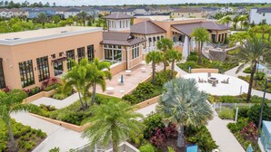 A residential area with multiple houses, a central courtyard with palm trees, and a small amphitheater. - Family Friendly 4Bd with Pool Solara Resort 1517 (Kissimmee)