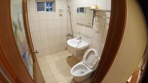 A small bathroom with a toilet, sink, and shower. - Wen Shan (Yuchi)