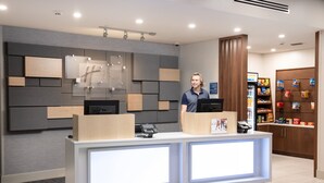 A modern reception desk with a digital display, a cash register, and a customer service counter.