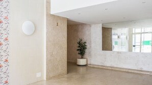Ruim, modern interieur met een minimalistisch ontwerp, met een grote open ruimte, een potplant en een wandlamp.