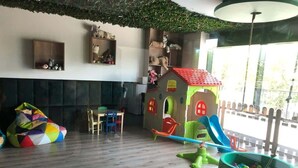 A playroom with a wooden floor, a colorful bean bag, a playhouse, and a slide. - Elegant Apartment in Zoliborz | Balcony and Parking (Warszawa)
