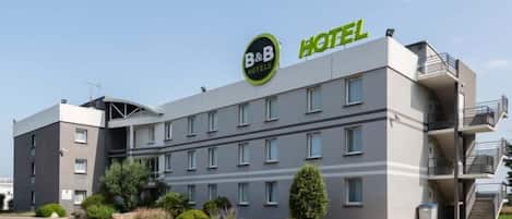 A B&B hotel with a modern design, multiple floors, and a parking lot.