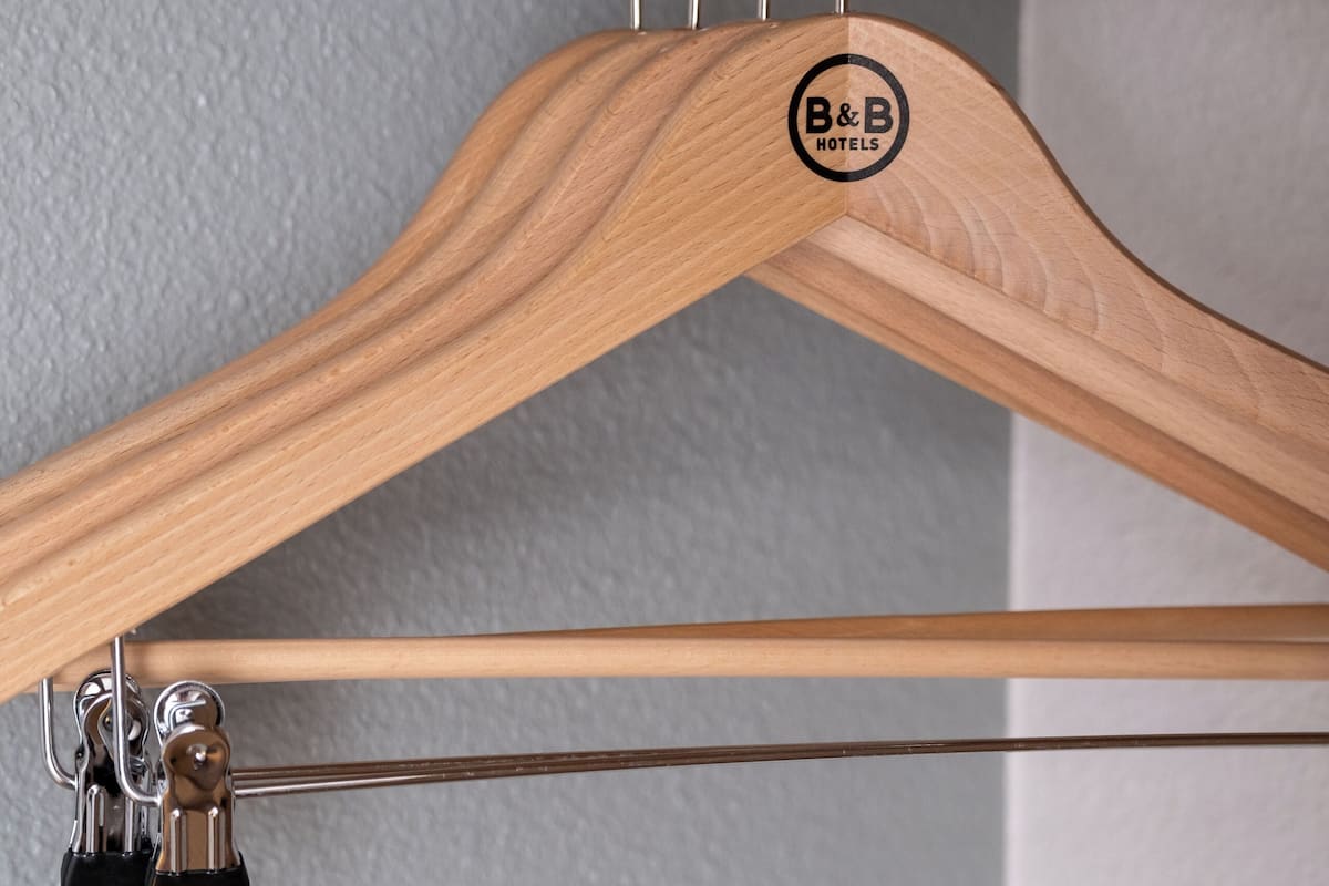 Un cintre en bois orné d’un logo, fixé à une structure métallique.