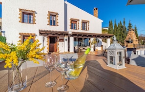 A patio with a table set for a meal, a bottle of wine, and a decorative lantern. - Amazing home in Mijas with private swimming pool, can be inside or outside (Mijas)