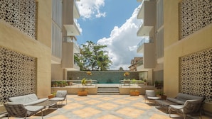 A courtyard with a pool, outdoor seating, and decorative walls. - Kiluwa Apartments & Spa  by Dunhill Serviced Apartments (Nairobi)