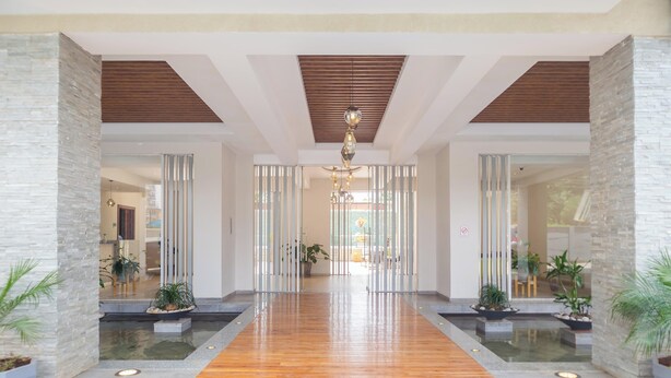 A spacious lobby with a wooden floor, stone walls, and a central chandelier. - Kiluwa Apartments & Spa  by Dunhill Serviced Apartments (Nairobi)
