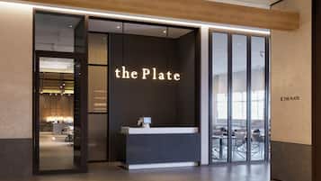 A modern reception area with a counter and a sign that reads 'the Plate'.