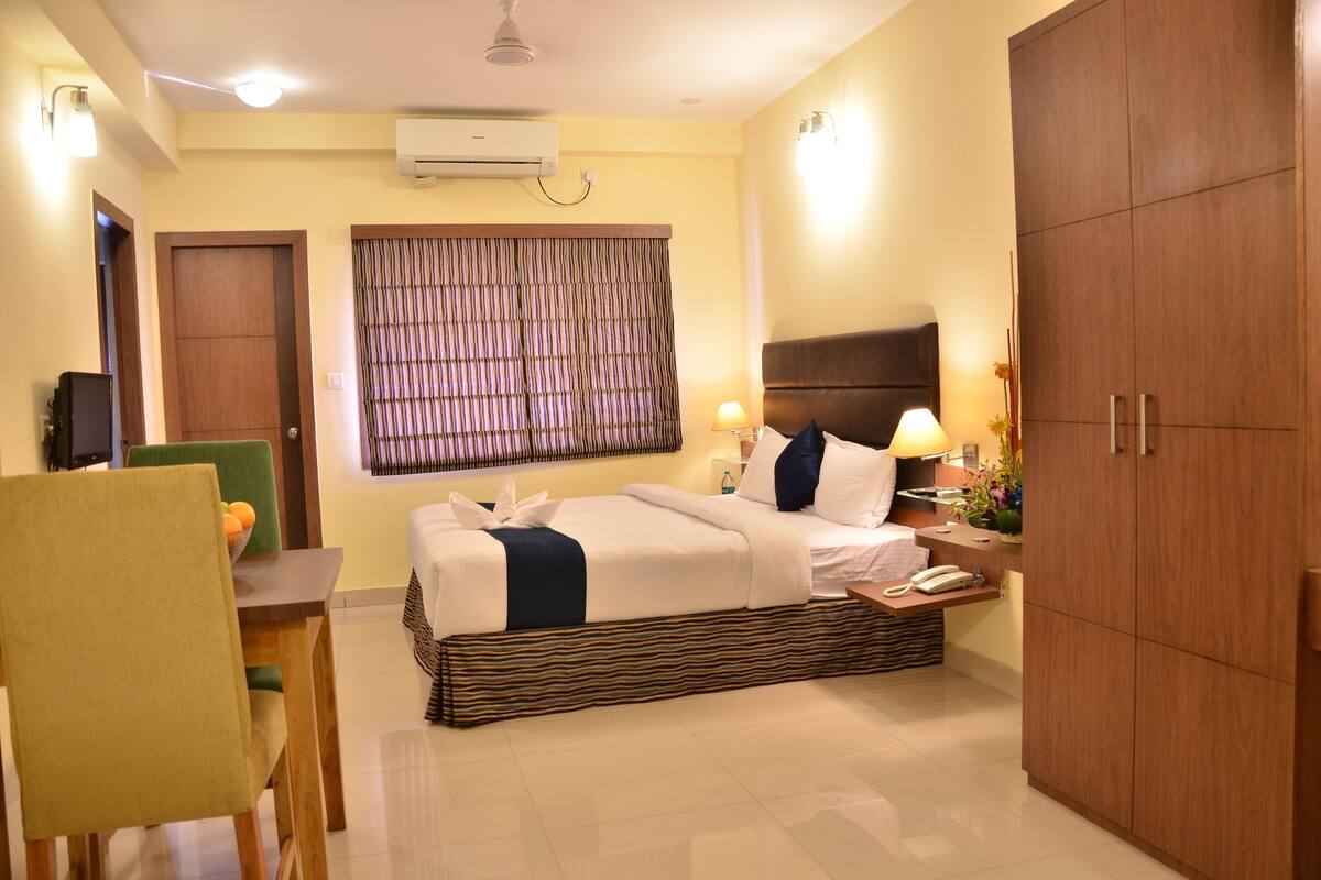 Une chambre d’hôtel comprenant un lit, une table de chevet, une lampe et une armoire.