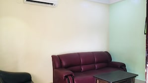 A living room with a red sofa, a black armchair, and a wooden coffee table. - IBD International Hotel Ilaro (Ilaro)