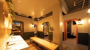 Une salle de bain moderne avec un banc en bois, deux lavabos et un miroir.