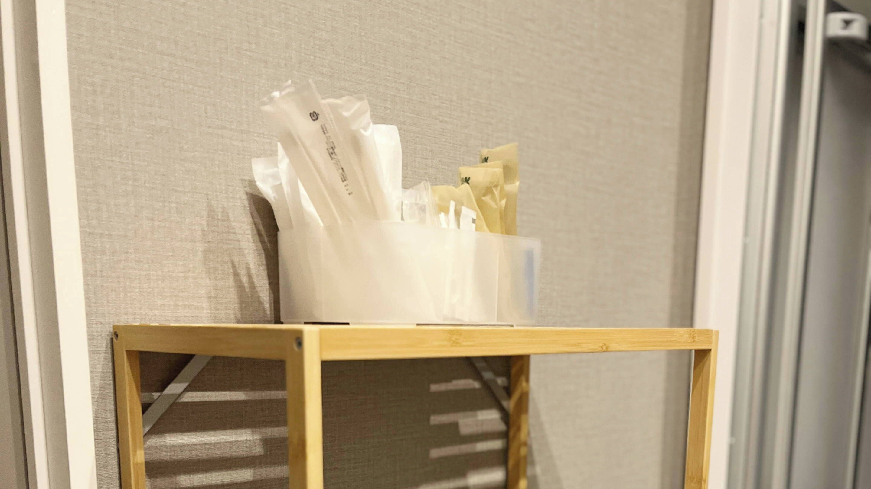 Una mesita de madera con un dispensador de pañuelos en una habitación de hotel.