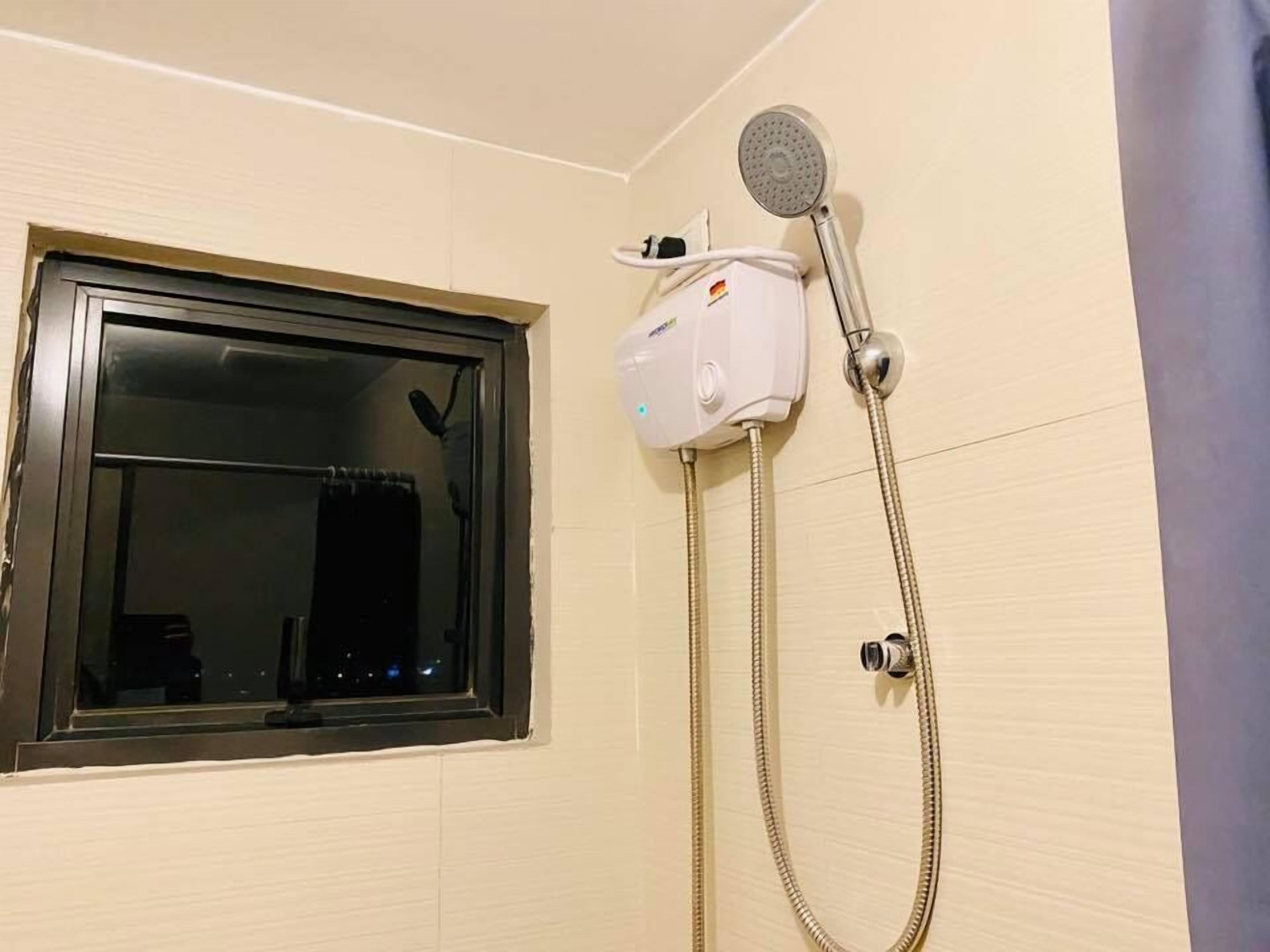 Bagno con finestra, soffione doccia e doccetta.