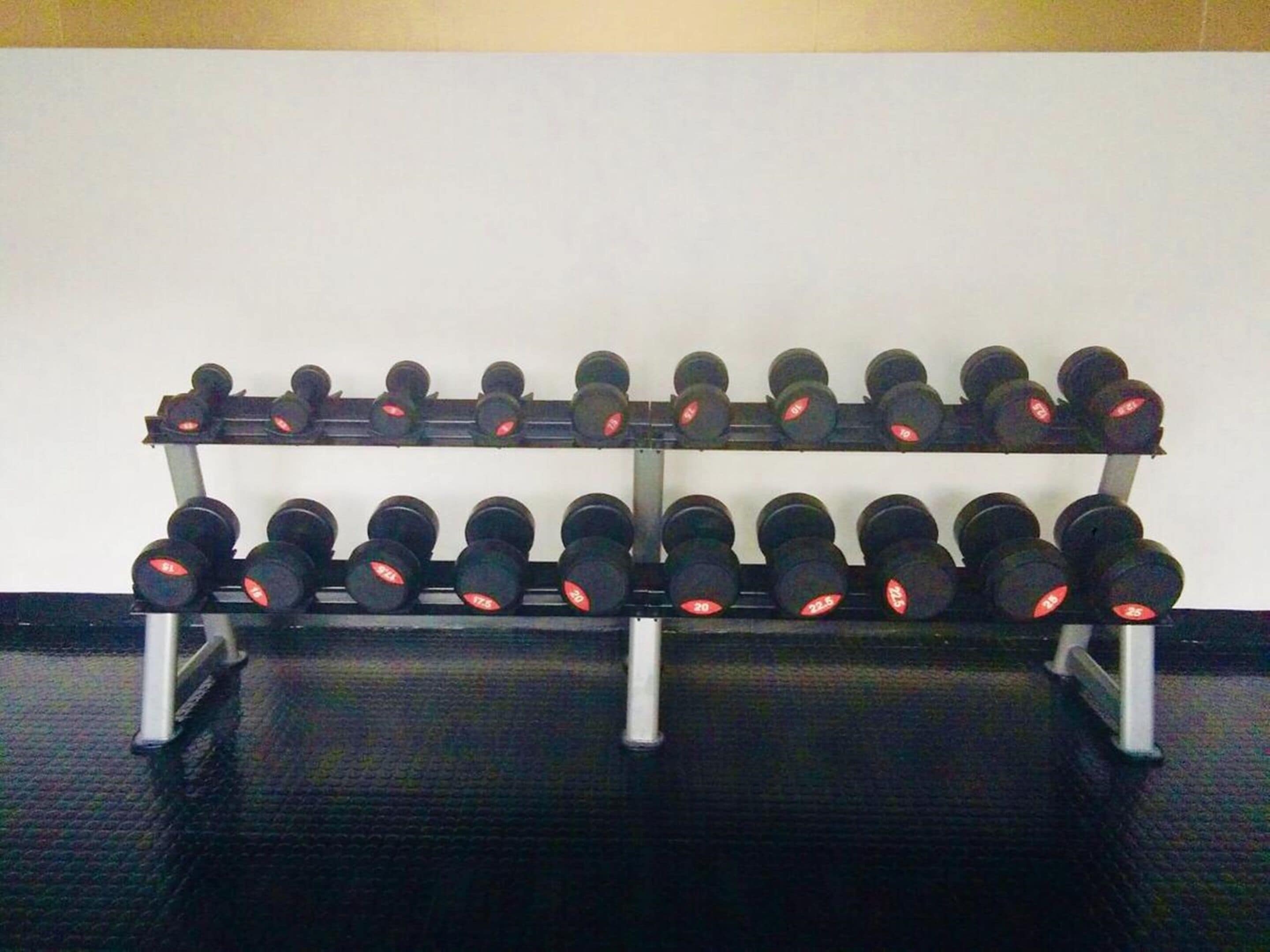 A rack of dumbbells with weights ranging from 5 to 25 lbs.
