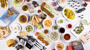 A variety of dishes and food items arranged on a table, including bread, rice, and various sauces.