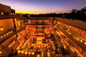 A multi-level hotel courtyard with outdoor seating and a central staircase. - 3102bce A Vedic Resort (Vagator)