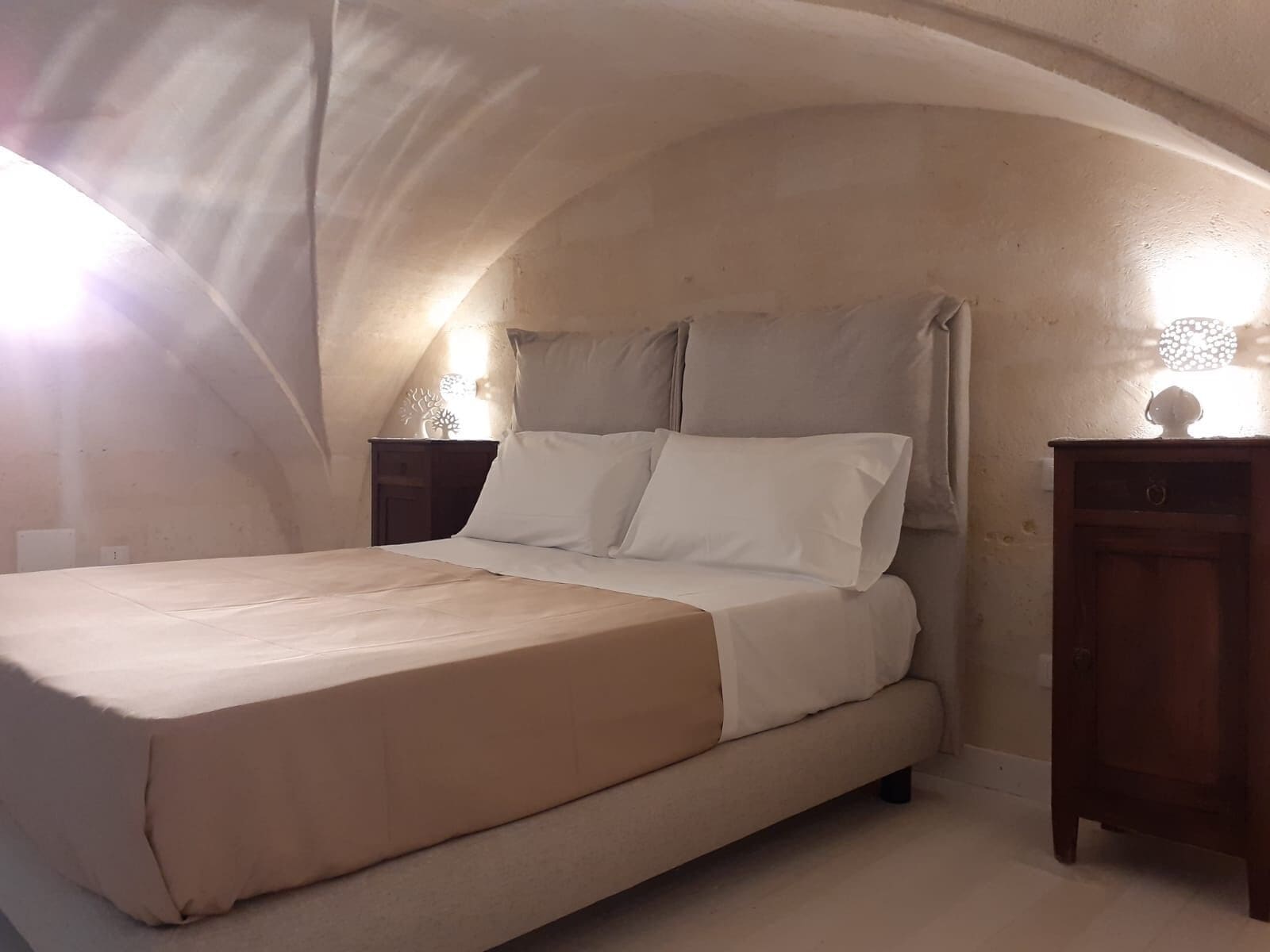 Un dormitorio con una cama individual, una mesita de noche y un aparador.