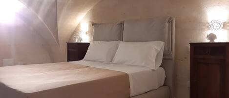 Un dormitorio con una cama individual, una mesita de noche y un aparador.