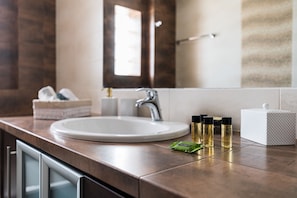 A bathroom with a white sink, a mirror, and toiletries on the counter. - Thresh Apartments Airport by Airstay (Spata-Artemida)