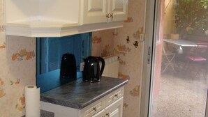 A kitchen with white cabinets, a countertop, and a coffee maker. - T4 near Hypercentre, private car box and loggia (Toulouse)
