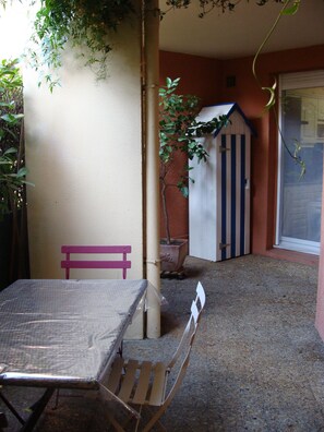 A patio area with a table and chairs, a small shed, and a potted plant. - T4 near Hypercentre, private car box and loggia (Toulouse)