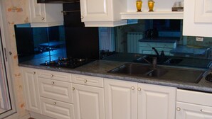 A kitchen with white cabinets, a granite countertop, a stove, and a sink. - T4 near Hypercentre, private car box and loggia (Toulouse)