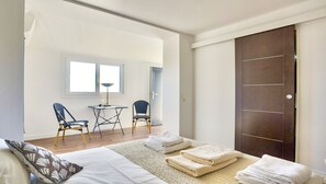 Una camera da letto con un letto, due sedie, un tavolino, una lampada e un armadio.